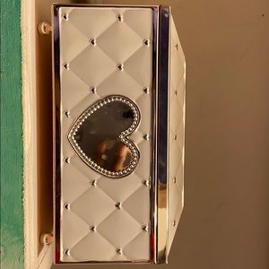 A pearl white jewelry box with silver hearts